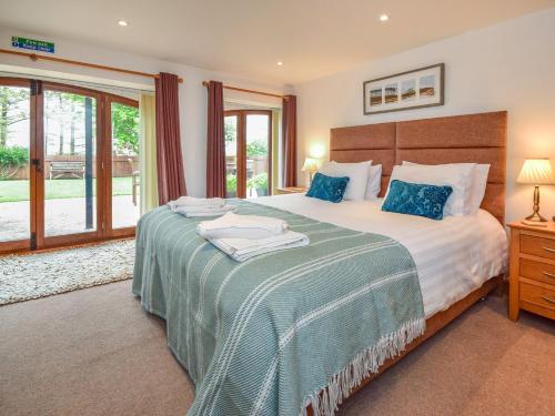 a bedroom with a large bed with blue pillows at 3 bed in South Molton HILRO in Mariansleigh