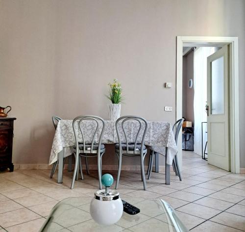 a dining room table with chairs and a vase of flowers on it at Casa Dolce Casa in Novi Ligure