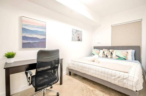 a bedroom with a desk and a bed and a chair at Peaceful 2BR Basement Suite Near Downtown Toronto - The Roland in Toronto