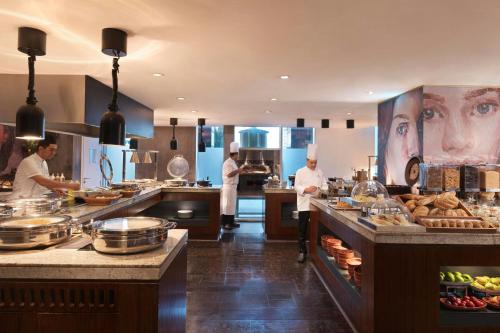 a kitchen with chefs preparing food in a restaurant at Ritz Carlton DIFC Downtown Dubai in Dubai
