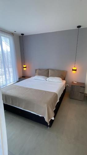 a bedroom with a large bed with two lights on it at Luxury Suite del Faro, Romance en la represa in Prado