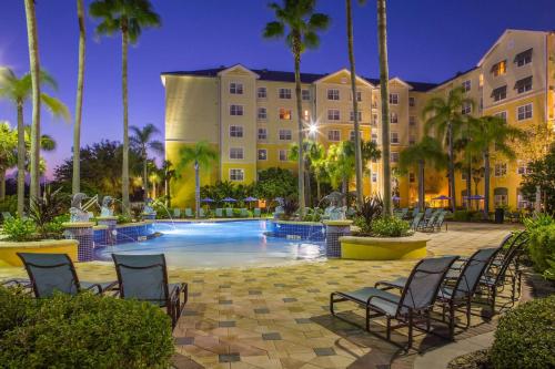 a pool at a resort with chairs and a building at Residence Inn by Marriott Orlando at SeaWorld in Orlando