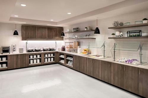 a large kitchen with wooden cabinets and shelves at Residence Inn by Marriott Houston NW Cypress in Cypress