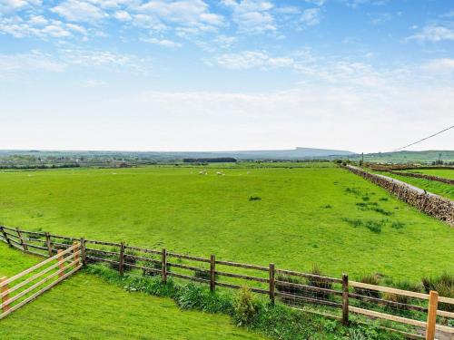 a large green field with a fence and animals in it at 2 Bed in Tosside 94056 in Tosside