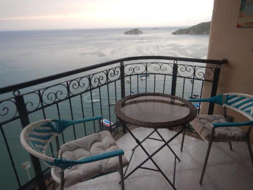 Un balcón con dos sillas y una mesa y el mar. en Rodadero mágico Apartamento frente al mar, en Santa Marta