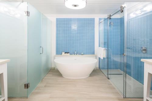 a bathroom with a tub and a glass shower at Windjammer Landing Resort and Residences in Gros Islet