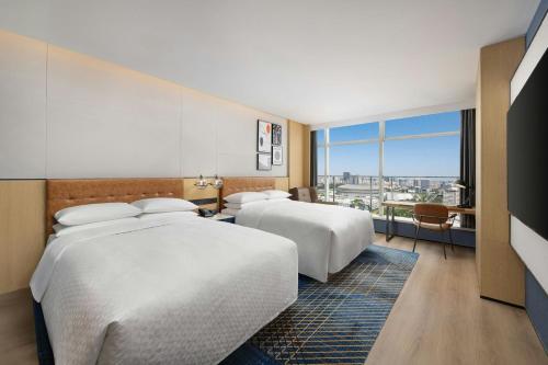 a hotel room with two beds and a large window at Four Points by Sheraton Beijing Sanlitun Workers Stadium in Beijing