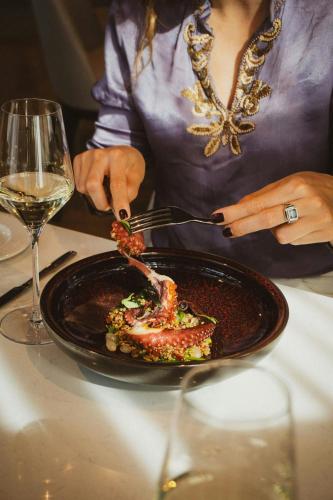 a woman sitting at a table with a plate of food at AC Hotel by Marriott Split in Split