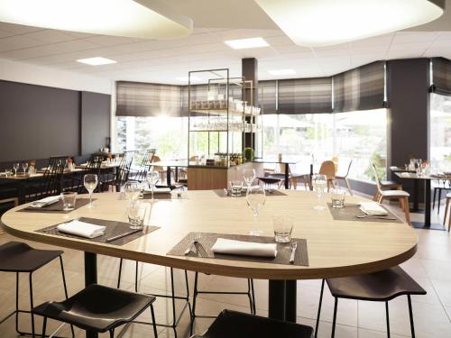 a dining room with a large table and chairs at Novotel Nancy in Nancy