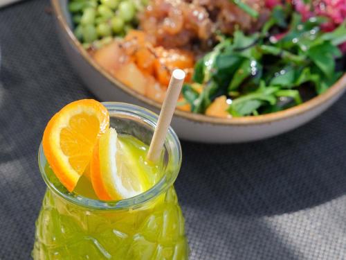 a bowl of salad and a drink with an orange slice at Novotel Narbonne Sud A9/A61 in Narbonne