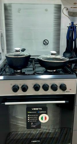 two frying pans sitting on top of a stove at City Center Apartment "Afsona mall" in Irvadan