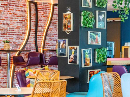 a restaurant with tables and chairs and a brick wall at Novotel Dijon Sud in Marsannay-la-Côte