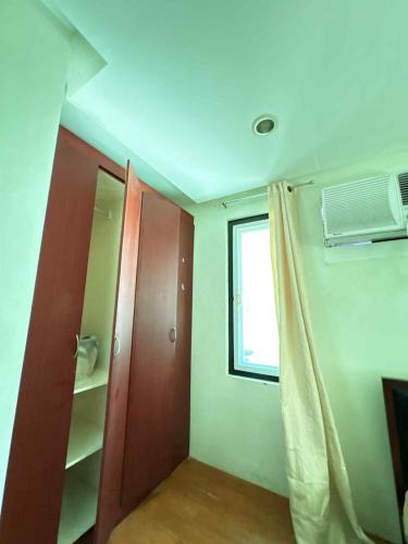 a room with a closet and a window and a door at Malibu Lanang SMX convention nearby Full house in Davao City