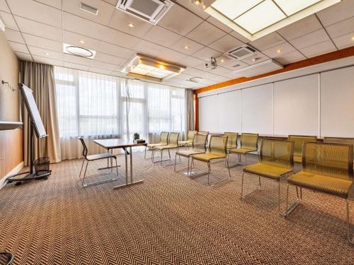 a conference room with chairs and a table and a screen at Novotel Dijon Sud in Marsannay-la-Côte
