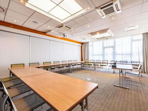 a classroom with tables and chairs in a room at Novotel Dijon Sud in Marsannay-la-Côte