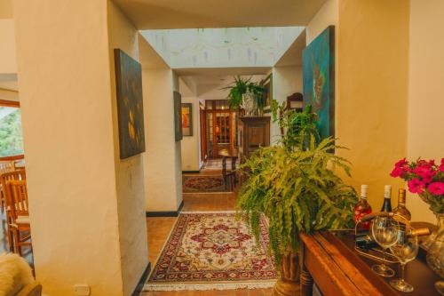 a hallway of a house with a table and flowers at Pousada Hortelã in Campos do Jordão