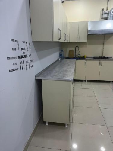 a kitchen with white cabinets and a counter top at FRIENDS Hostel Baku in Baku