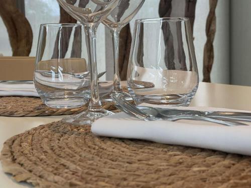 a table with three wine glasses and a napkin at Novotel Pau Pyrénées in Lescar