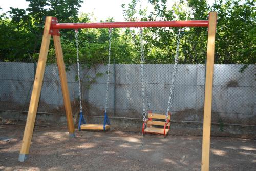 an empty swing set with two swings at Niki Hotel Apartments in Ialyssos