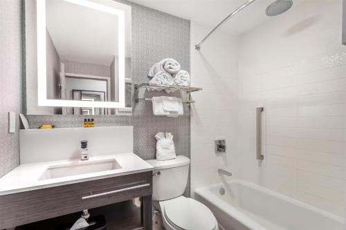 a bathroom with a sink and a toilet and a tub at Best Western Downtown PLUS Music Row in Nashville