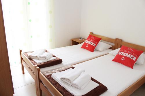 two beds in a room with red and white towels at Apartments Bella in Vodice