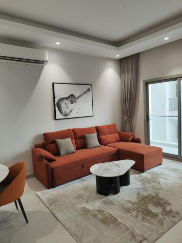 salon z brązową kanapą i stołem w obiekcie Muscat City Stay - 2BR Apt 308 near Grand & Avenue Mall w mieście Ghukra