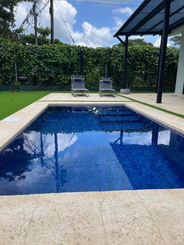 a swimming pool with two lawn chairs next to it at Casa Flor in Playa Avellana