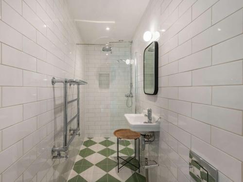 Baño de azulejos blancos con lavabo y taburete en 2 bed in Blandford Forum 88193, en Durweston
