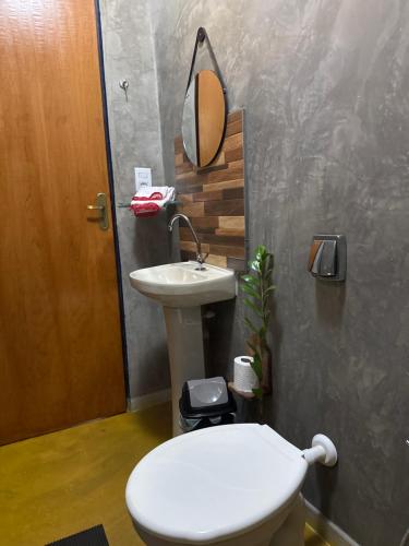 a bathroom with a white toilet and a sink at Pousada Recanto do Tucano in Cavalcante