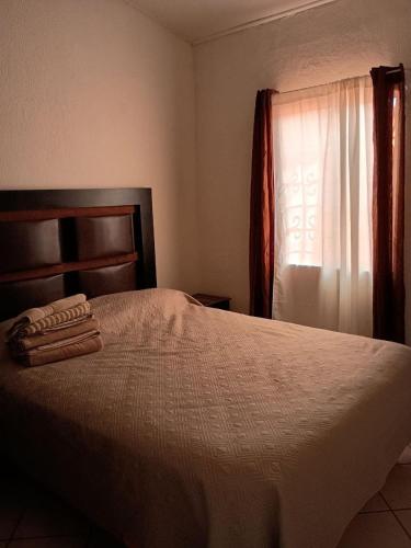 1 dormitorio con 1 cama y ventana con toallas en Casa cerca de la playa, en Ensenada