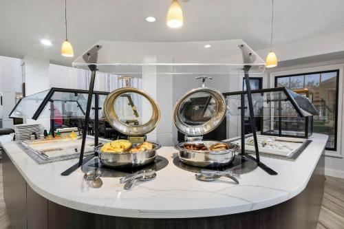 a buffet with three mirrors and bowls of food at Staybridge Suites Toledo/Maumee by IHG in Maumee