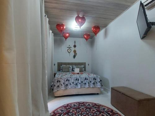 a bedroom with a bed with red hearts on the ceiling at Chalé na lata in Pirenópolis