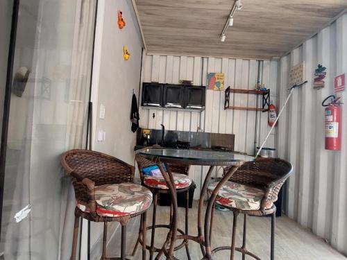 Una mesa y dos taburetes de bar en un remolque. en Chalé na lata, en Pirenópolis