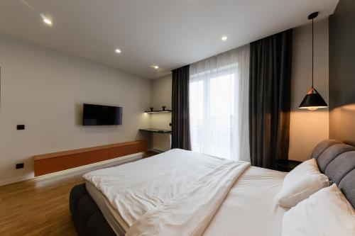 a hotel room with a bed and a television at Luxury Apartments Babyak in Uzhhorod