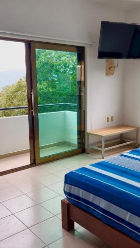a bedroom with a bed and a large window at Hotel Monkey House Tuxtla Gutiérrez in Tuxtla Gutiérrez