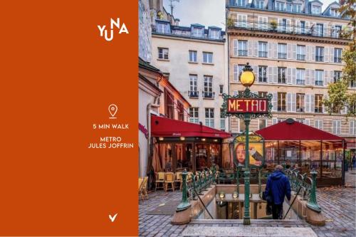 Una persona che cammina per una strada in una città di Yuna Montmartre - ApartHotel a Parigi