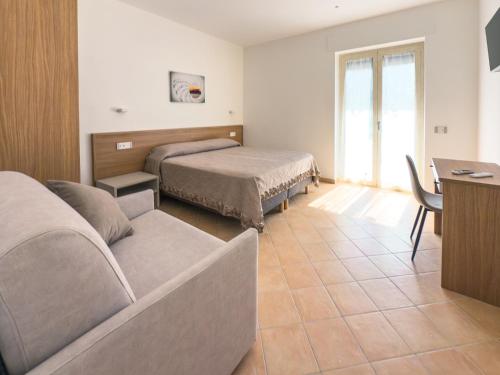 a hotel room with two beds and a desk and a table at Jazz & Blues Apartments near " Sentiero degli Dei " in Agerola
