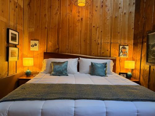 a bedroom with a large bed with wooden walls at Casa Colibri Chirripó in Herradura
