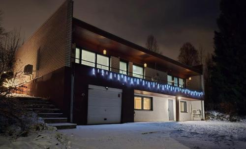 a brick house with a garage at night at Santa's choice for Aurora hunters , Sauna and jacuzzi in Rovaniemi