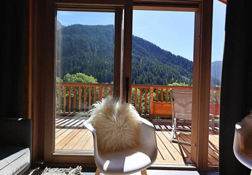 Camera con sedia e balcone con vista. di Mio – Loft alpin lumineux avec vue montagne a Champagny-en-Vanoise
