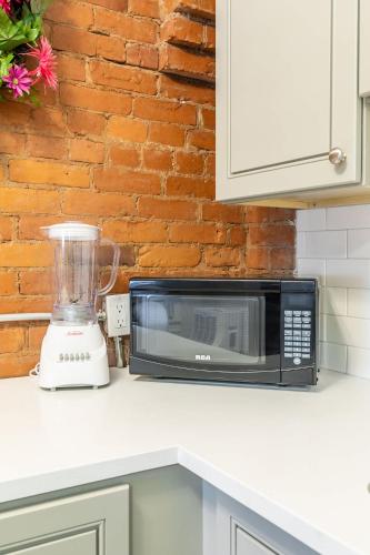 a kitchen counter with a microwave and a blender at Boutique 2BR Apartment on James St North Sleeps 6 in Hamilton