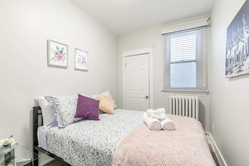 a small bedroom with a bed and a window at Boutique 2BR Apartment on James St North Sleeps 6 in Hamilton