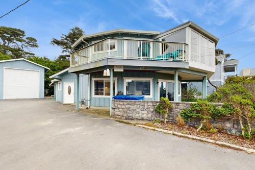 a house with a balcony on top of a driveway at Neptune's Trident in Lincoln Beach