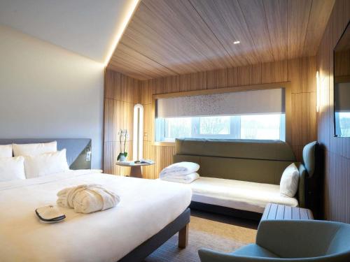 a hotel room with two beds and a window at Novotel Reims Tinqueux in Reims