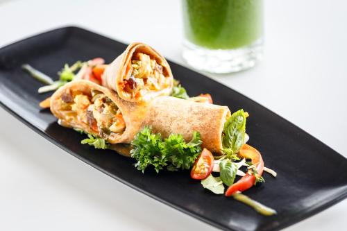 a black plate with a sandwich and a salad at Windjammer Landing Resort and Residences in Gros Islet