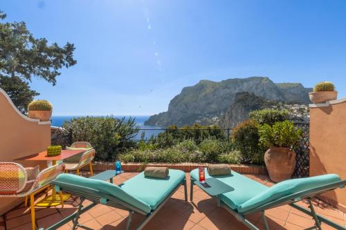 a patio with a table and chairs and a view of the ocean at Hotel Punta Tragara in Capri