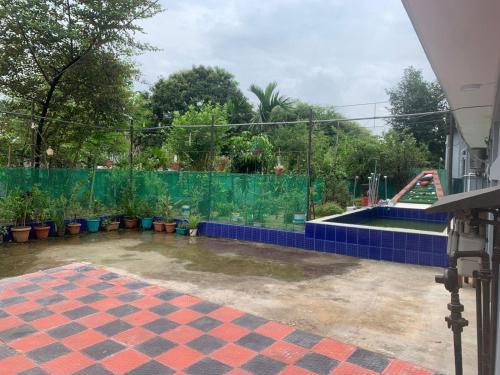 a tennis court with blue tiles and a fence at Dream Palace in Sylhet