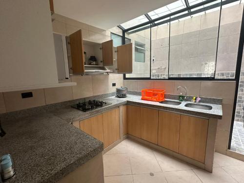 a kitchen with wooden cabinets and a large window at Casa de Stephano in Lima