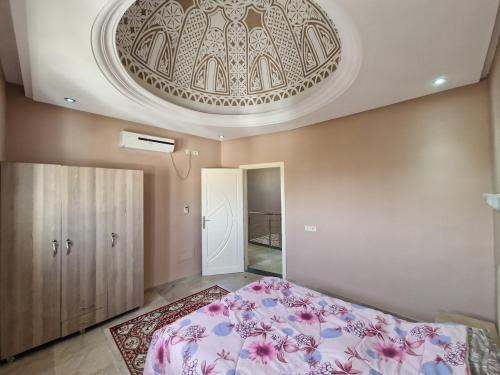 1 dormitorio con 1 cama grande y techo en Villa sultan Djerba, en Midoun