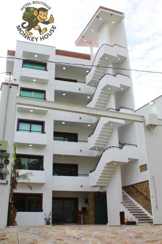 a white building with stairs on the side of it at Hotel Monkey House Tuxtla Gutiérrez in Tuxtla Gutiérrez
